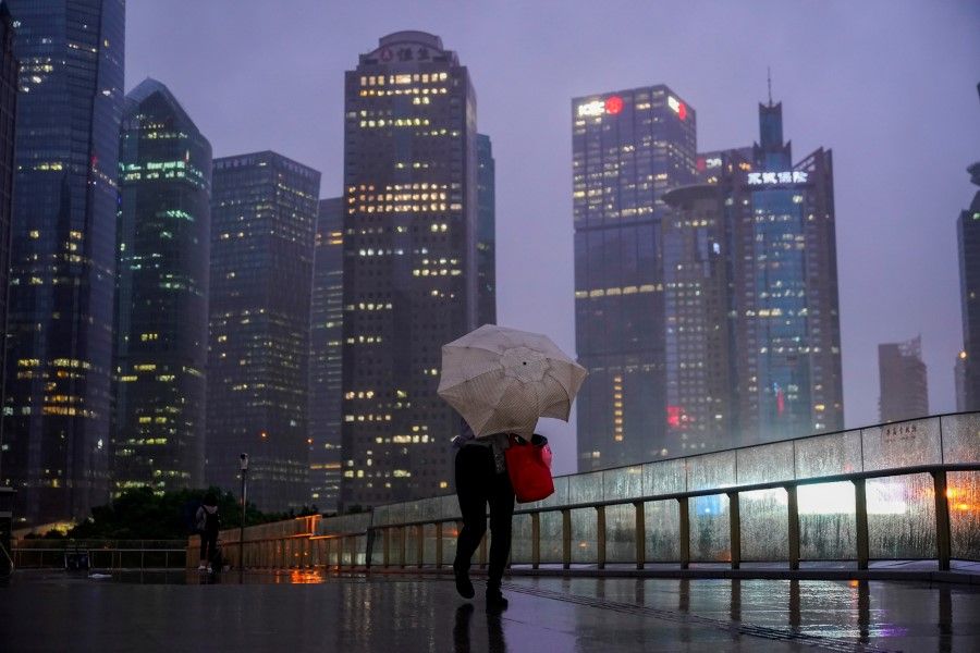 A woman walks with an umbrella amid rainfall in Shanghai, China, 13 September 2021. (Aly Song/Reuters)