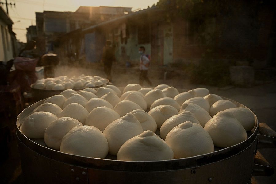 A boy walks past steamed buns on a street in Beijing, China, on 28 September 2022. (Noel Celis/AFP)
