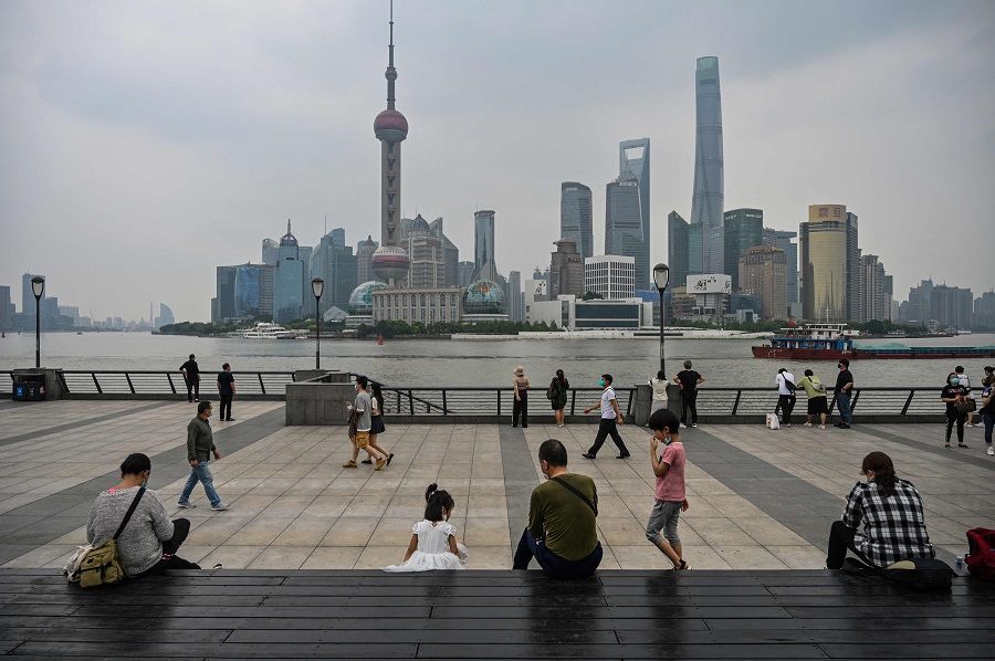 People gather on the Bund along the Huangpu River in Shanghai, China, on 1 June 2022. (Hector Retamal/AFP)