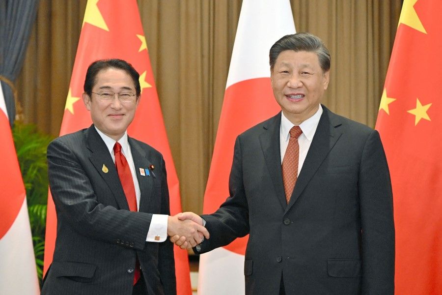 Japan's Prime Minister Fumio Kishida (left) shakes hands with China's President Xi Jinping during their meeting in Bangkok on 17 November 2022, on the sidelines of the Asia-Pacific Economic Cooperation (APEC) Summit. (Jiji Press/AFP)