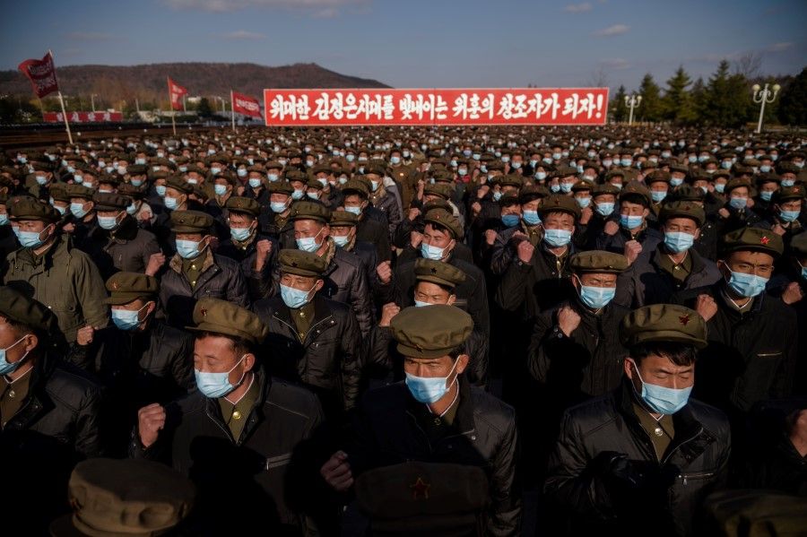 In a photo taken on 20 November 2020, divisions of returning elite party members attend a meeting to pledge loyalty before the portraits of late North Korean leaders Kim Il Sung and Kim Jong Il, upon their arrival at Kumsusan palace in Pyongyang, following their deployment to rural provinces to aid in recovery efforts amid damage caused by a September typhoon. (Kim Won Jin/AFP)