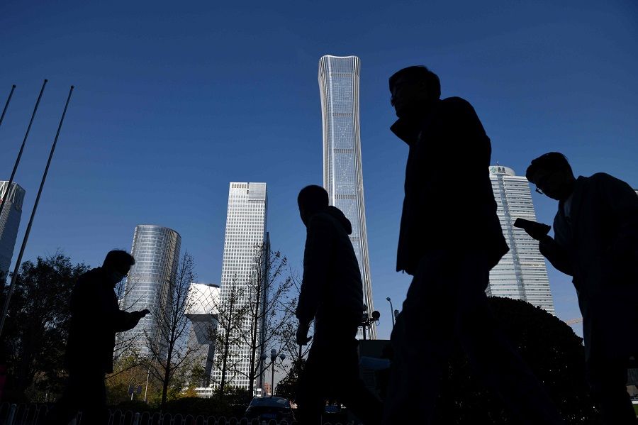 People walk past skyscrapers in the central business district in Beijing, China, on 24 November 2020. (Greg Baker/AFP)