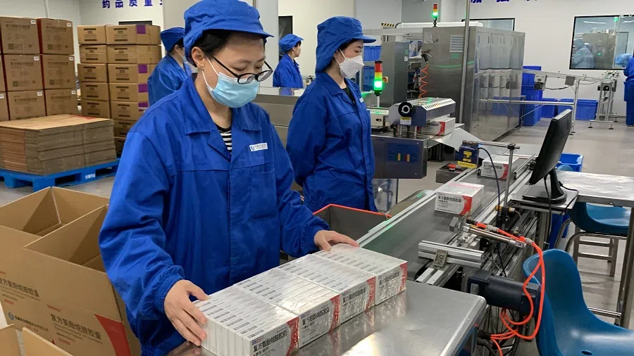 Workers packing fever-reducing medication at a pharmaceutical factory in Beijing.  (SPH Media )