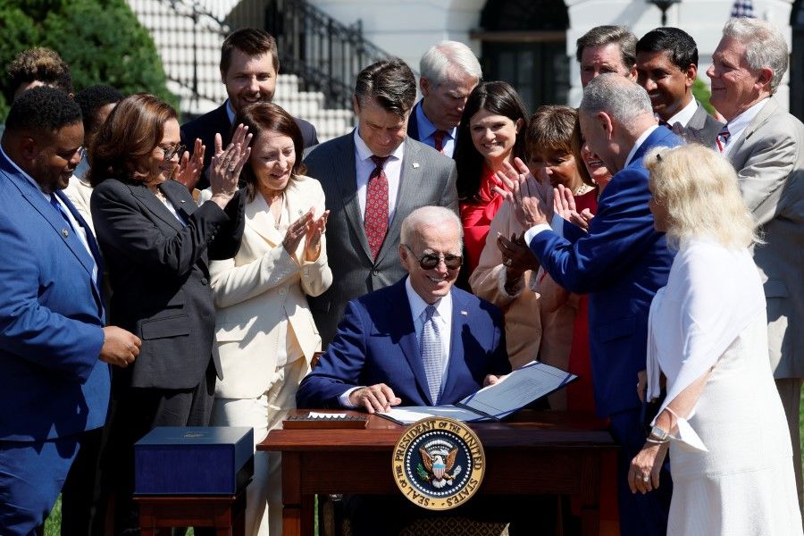 US President Joe Biden signs the CHIPS and Science Act of 2022 alongside Vice President Kamala Harris, House of Representatives Speaker Nancy Pelosi and Joshua Aviv, founder and CEO of SparkCharge, on the South Lawn of the White House in Washington, US, 9 August 2022. (Evelyn Hockstein/Reuters)