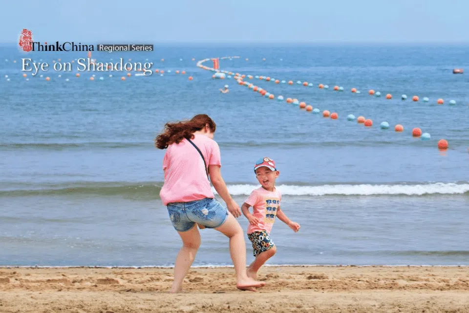 ​A woman has fun with her playful young boy on Yantai beach. Because of its fair weather, extensive coastline and abundant tourist sites, Yantai in Shandong province is a very popular summer retreat. (iStock)
