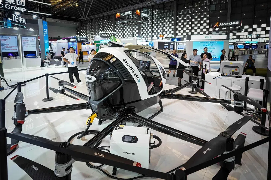 People look at EHang’s passenger-carrying electric unmanned aerial vehicle at the World Artificial Intelligence Conference (WAIC) in Shanghai, China, on 4 July 2024. (AFP)