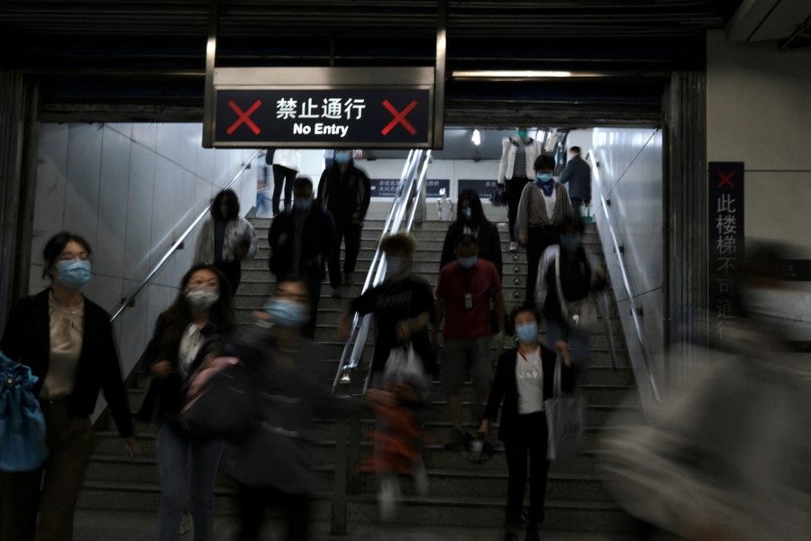 People walk inside a subway station during morning rush hour in Beijing, China, 6 May 2022. (Tingshu Wang/Reuters)
