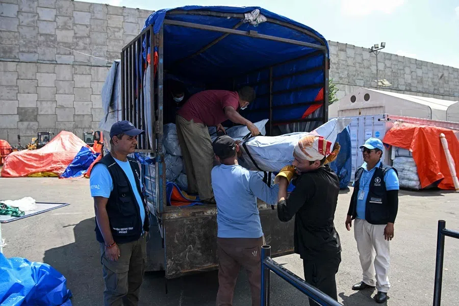 Workers unload emergency relief supplies from the United Nations World Food Programme (WFP) for flash flood victims at Tribhuvan International Airport's cargo area in Kathmandu on 17 September 2026.
