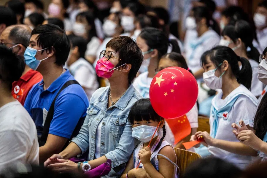 Guests attend a flag-raising ceremony to mark China's National Day at a school in the Tung Chung district of Hong Kong on 1 October 2021, which commemorates the 72nd anniversary of the establishment of the People's Republic of China. (Isaac Lawrence/AFP)