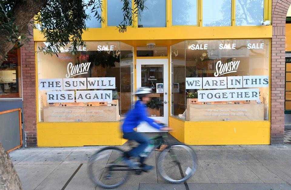 A boy rides past a supportive sign posted on a storefront in San Francisco, California on 01 April 2020, during the Covid-19 outbreak. (Josh Edelson/AFP)