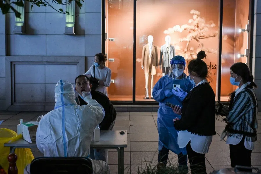 A health worker takes a swab sample from a man to test for the Covid-19 coronavirus in the Huangpu district in Shanghai on 24 October 2022. (Hector Retamal/AFP)