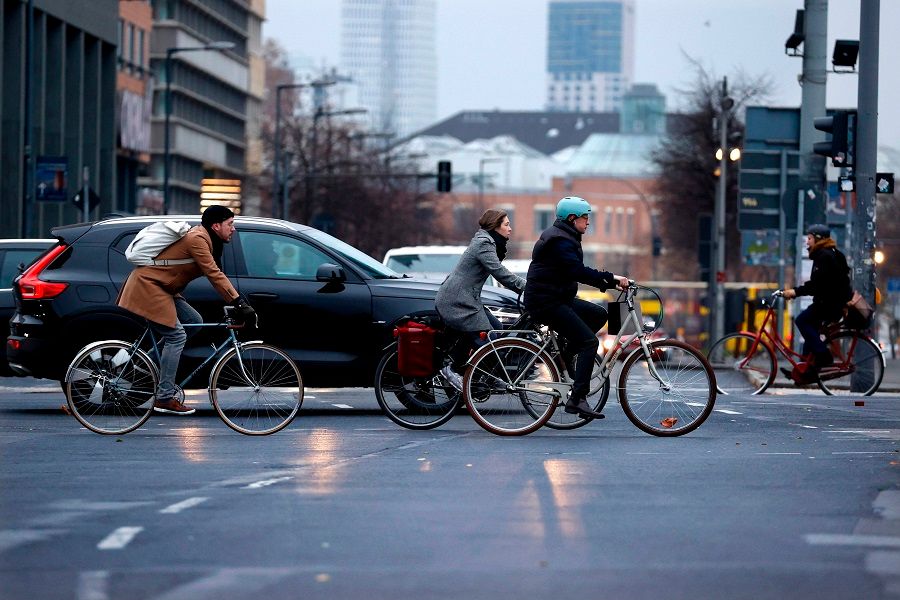 Bicycle and car commuters are seen crossing a busy intersection at Potsdamer Platz in Berlin, Germany, on 7 December 2020. (Odd Andersen/AFP)