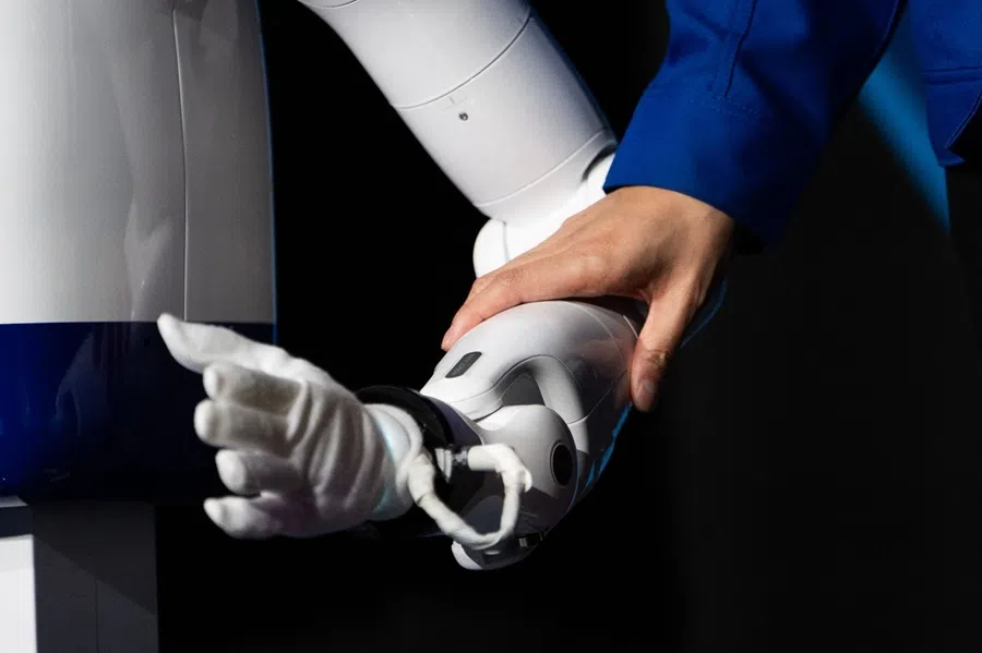 Zeals CEO Masahiro Shimizu holds the arm of the company's semi-domestic compact humanoid "D1" helper robot at Shibuya Scramble Hall in Tokyo on 5 August 2026.