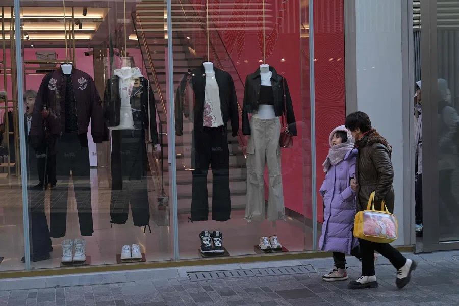 People walk at a shopping mall in Beijing on 16 January 2024. (Pedro Pardo/AFP)