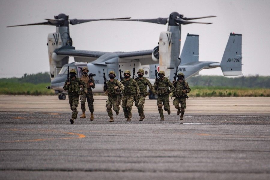 Members of the Japan Ground Self-Defense Force take part in a military display in front of a V-22 Osprey, for service members from 18 countries on the sidelines of the Pacific Amphibious Leaders Symposium 2022 (PALS 22), at the Japan Ground Self-Defense Force's Camp Kisarazu in Chiba prefecture on 16 June 2022. (Philip Fong/AFP)