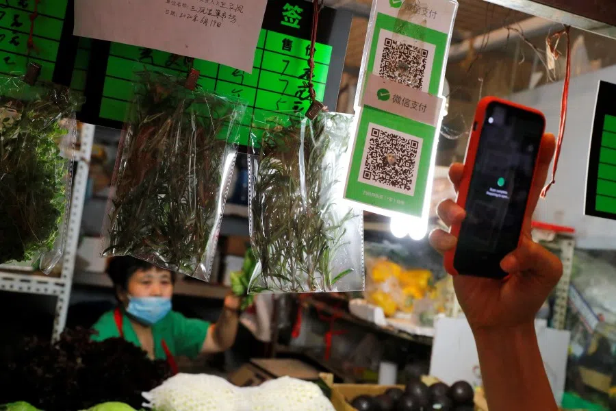 A person scans the QR code of the digital payment services WeChat Pay at a fresh market in Beijing, 8 August 2020. (Thomas Peter/REUTERS)