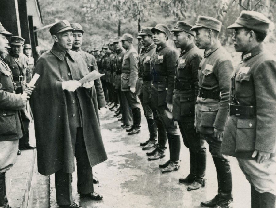 Generalissimo Chiang Kai-shek (centre, holding open sheet) inspecting the front lines in Guilin in 1944. Bai Chongxi is on the right of Chiang.