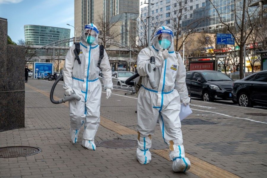Workers wearing protective gear in Beijing, China, on 15 December 2022. (Bloomberg)
