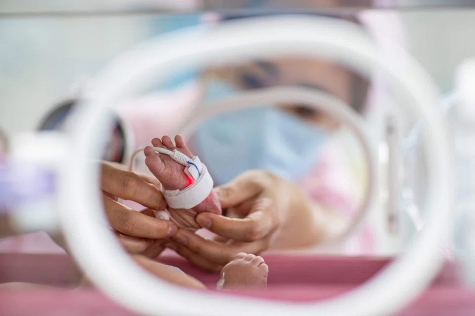A nurse takes care of a newborn baby at a hospital in Xinghua, Jiangsu province, China, on 10 May 2024. (AFP)