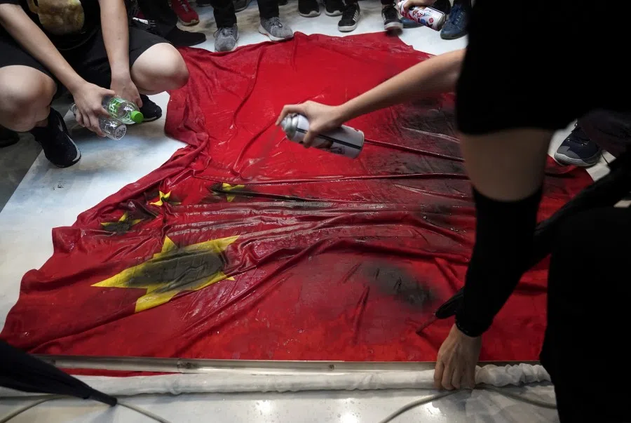 Anti-government protesters spray-paint a Chinese flag in Hong Kong. (Aly Song/REUTERS)