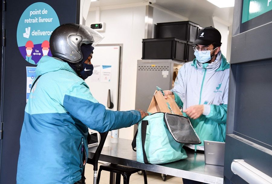 This file photo shows a delivery man picking up takeaway orders at Deliveroo's company communal kitchens in Aubervilliers outside Paris, France, on 6 May 2021. (Alain Jocard/AFP)