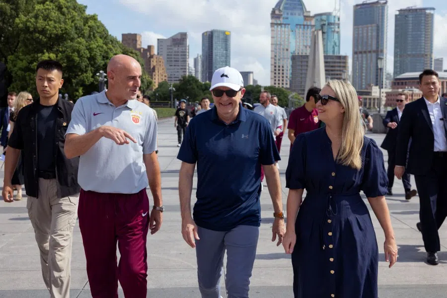 Australia’s Prime Minister Anthony Albanese and his fiancee Jodie Haydon walk along the Bund with Shanghai Port FC Manager Kevin Muscat, in Shanghai, China, on 13 July 2025. (Dominic Lorrimer/Reuters)