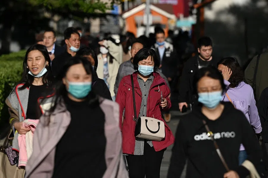 People walk on a footpath in Beijing, China, on 25 March 2023. (Greg Baker/AFP)