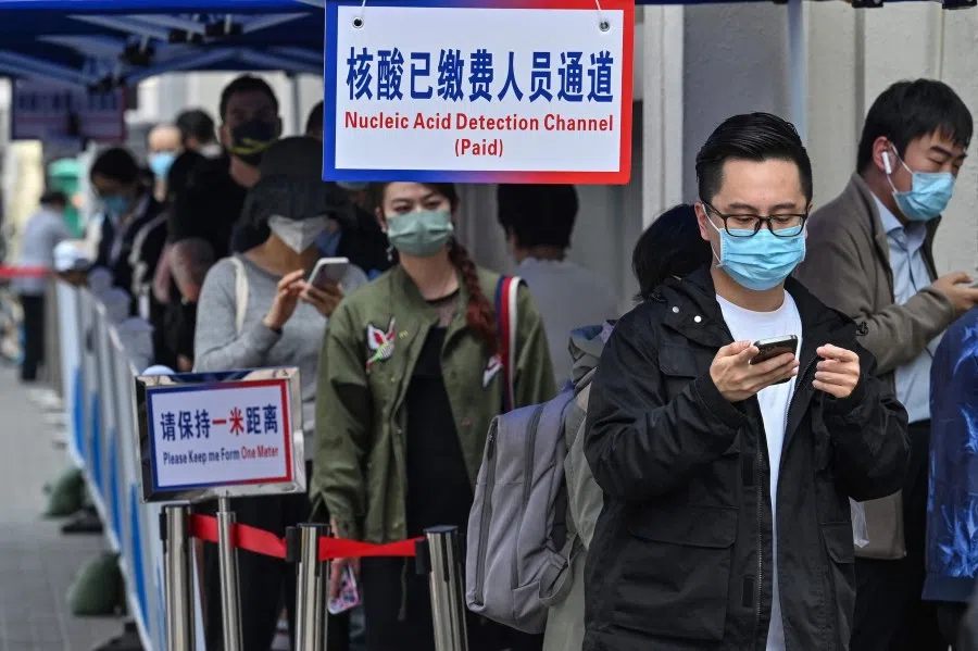 People queue up to be tested as a measure against Covid-19 at the Shanghai Jin'an Central Hospital, in Shanghai on 14 March 2022. (Hector Retamal/AFP)