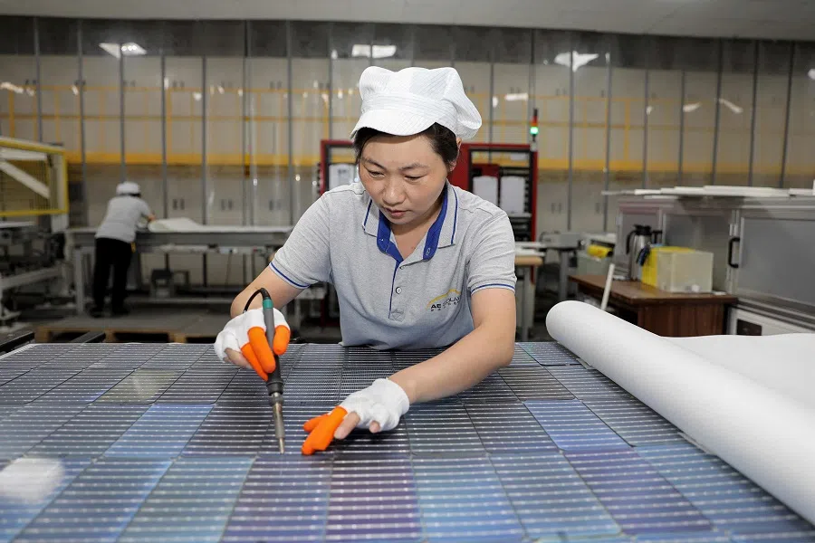 This photo taken on 5 September 2023 shows a worker producing solar photovoltaic modules used for solar panels at a workshop in Huaian, Jiangsu province, China. (AFP)