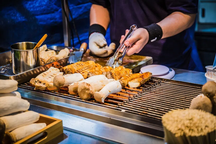A food stall selling grilled king oyster mushrooms on sticks at the Feng Chia Night Market. (iStock)