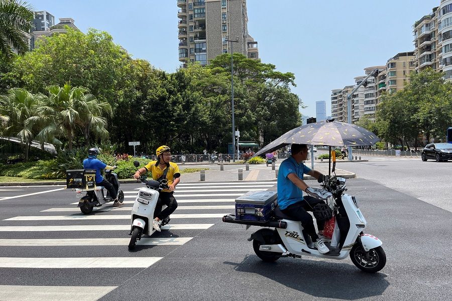 Delivery workers ride scooters in Shenzhen, Guangdong province, China, on 2 June 2023. (David Kirton/Reuters)