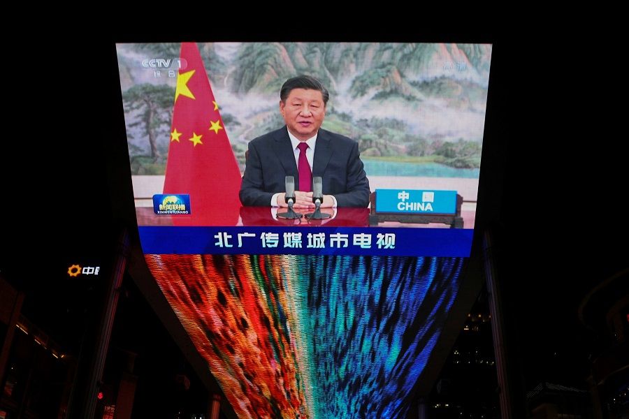 A screen displays a CCTV state media news broadcast showing Chinese President Xi Jinping addressing world leaders at the G20 meeting in Rome via video link at a shopping mall in Beijing, China, 31 October 2021. (Thomas Peter/Reuters)