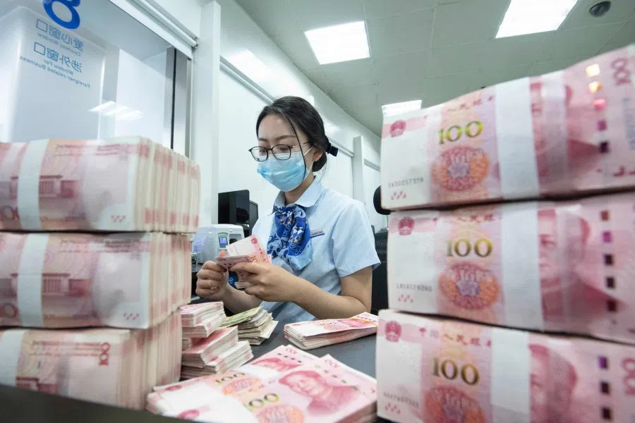 This photo taken on June 13, 2023 shows a bank employee counting 100-yuan notes at a bank counter in Nanjing, in China's eastern Jiangsu province. (AFP)