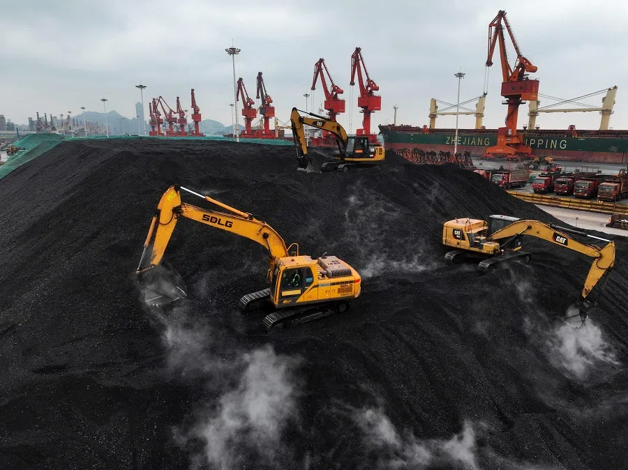 Diggers pile coal after it was unloaded from a ship at the coal terminal of Lianyungang Port, Jiangsu province, China, on 15 December 2023. (AFP)