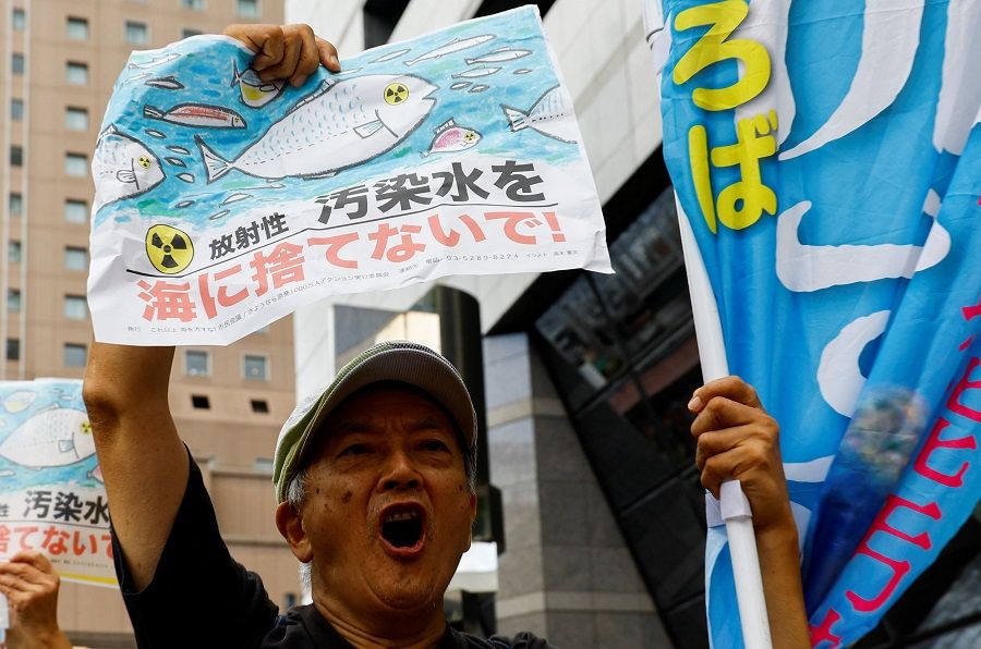 A protester holds a placard that reads "No radiation contaminated water into the sea" during a rally against Japan's plan to discharge treated radioactive water from the crippled Fukushima Daiichi nuclear plant into the ocean, in front of the headquarters of Tokyo Electric Power Company (TEPCO), the operator of the nuclear plant in Tokyo, Japan, 24 August 2023. (Kim Kyung-Hoon/Reuters)