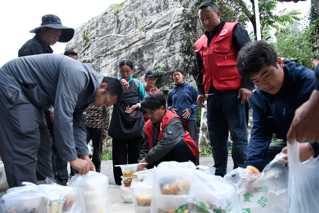 Volunteers distribute meals to affected residents at a temporary shelter, after a mudslide in Gyirong county, Shigatse, Tibet, on 29 August 2026.
