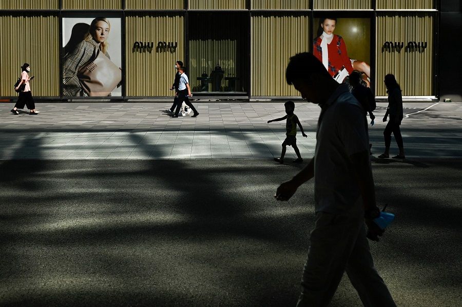 Pedestrians walk past advertising outside a mall in Beijing, China, on 24 August 2022. (Wang Zhao/AFP)