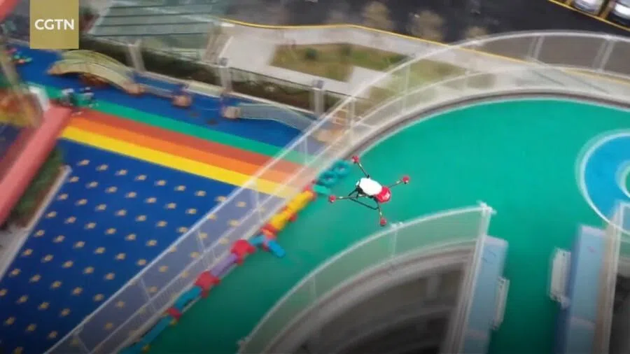 A screenshot from a video featuring a drone guided by the BeiDou system flying above a building during the Covid-19 pandemic.