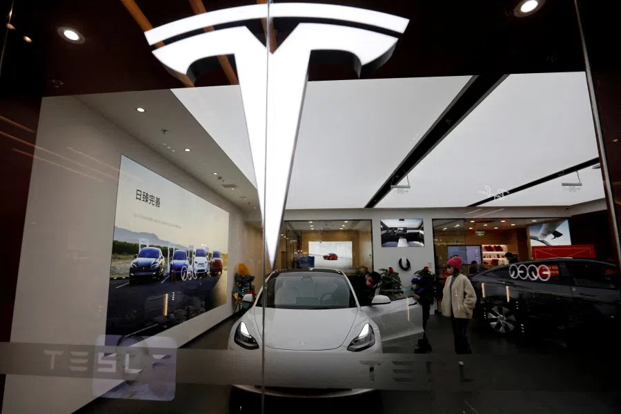 Visitors check a Tesla Model 3 car next to a Model Y displayed at a showroom of the US electric vehicle (EV) maker in Beijing, China, on 4 February 2023. (Florence Lo/Reuters)