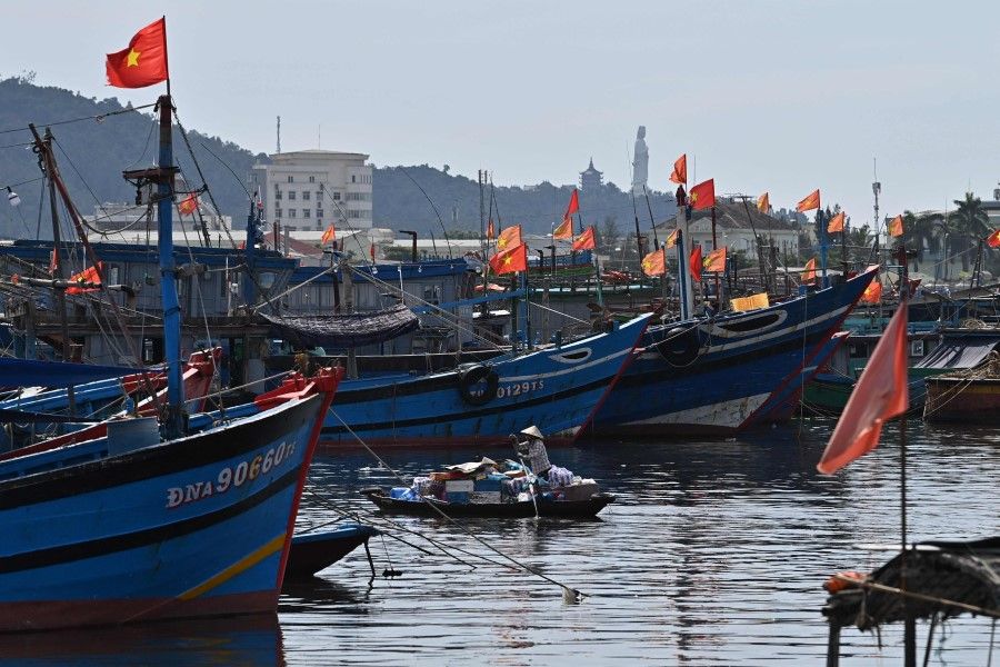 A woman sails her boat to sell goods at a port in Danang on 24 June 2023. (Nhac Nguyen/AFP)