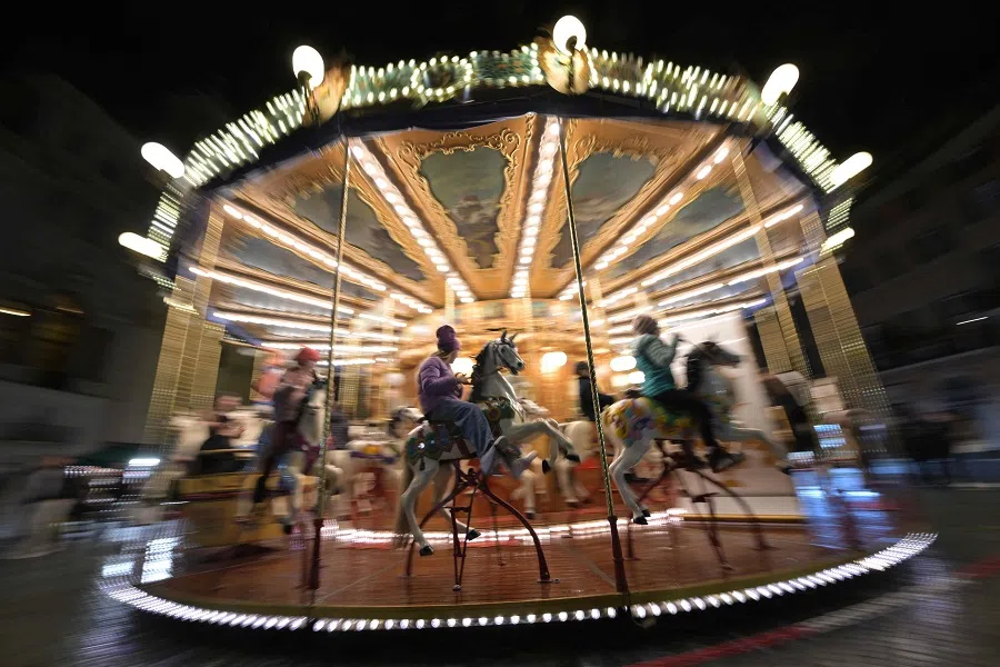 Children sit on the wooden horses of a carousel at a Christmas market in Piazza Navona on 15 December 2023 in Rome, Italy. (Andreas Solaro/AFP)