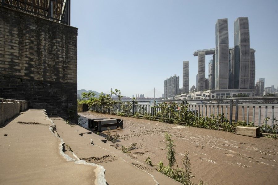Footprints are seen in mud left by receded floodwaters on the banks of a square overlooking the confluence of the Yangtze and Jialing Rivers in Chongqing, 28 July 2020. (Qilai Shen/Bloomberg)