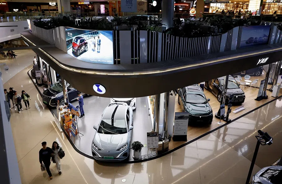 Electric vehicle (EV) models are displayed at the booths of Denza, a joint venture between Mercedes-Benz Group AG and BYD Auto, and Chinese EV maker Voyah, at a shopping mall in Beijing, China, 3 November 2023. (Tingshu Wang/Reuters)