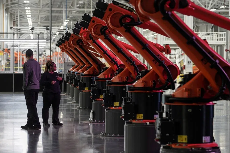 People are seen next to robotic arms for a second battery tray assembly line at the opening of a Mercedes-Benz electric vehicle Battery Factory, in Woodstock, Alabama, US, 15 March 2022. (Elijah Nouvelage/Reuters)