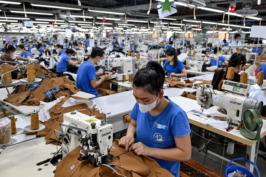 Workers stitch apparels at a garment factory in Vietnam's Thai Nguyen province on 2 July 2025. Vietnam, a global manufacturing hub dependent on exports, faces a potential "reciprocal tariff" hike from 10-46% without a US trade deal. (Nhac Nguyen/AFP)