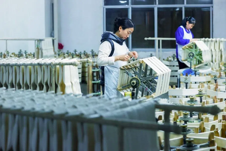 Employees work at a silk factory in Chongqing’s Qianjiang district, southwestern China, on 1 March 2026. (AFP)