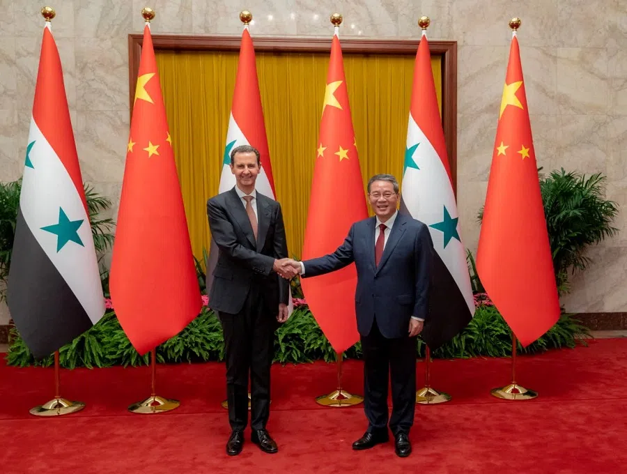 Chinese Premier Li Qiang (right) shakes hands with Syria's President Bashar al-Assad in Beijing, China, in this handout picture released by the Syrian Presidency on 25 September 2023. (Syrian Presidency/Handout via Reuters)