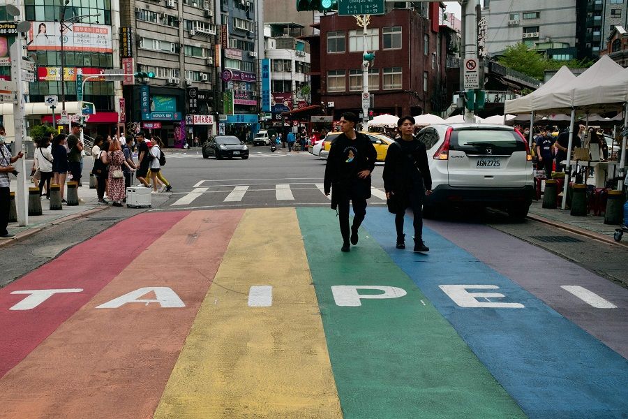 This picture taken on 14 April 2023 shows people walking down a street at the Ximen district in Taipei, Taiwan. (Sam Yeh/AFP)
