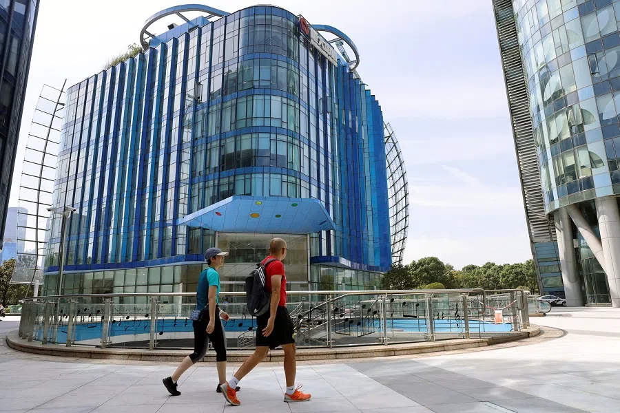 People walk past the Evergrande Center of China Evergrande Group in Shanghai, China, 24 September 2021. (Aly Song/Reuters)
