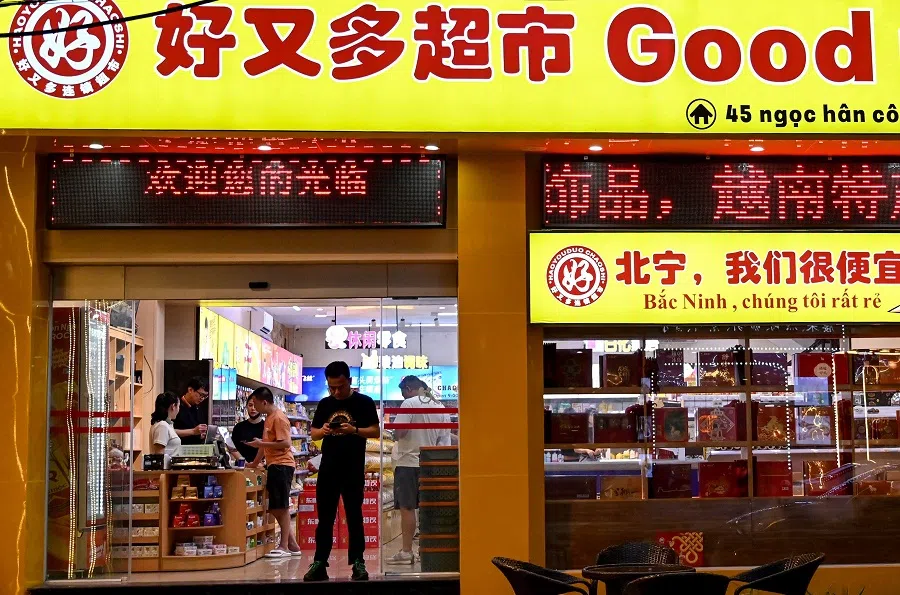 This photo taken on 22 April 2024 shows customers standing inside a convenience store in the Chinatown district of Bac Ninh province.